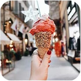Hand holding red icecream. Street on the background