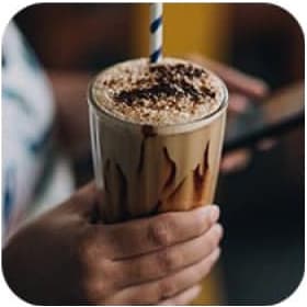 Hand holding the glass with chocolate milk shake